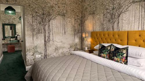 a bedroom with a large bed and trees on the wall at Atholl Arms Hotel Dunkeld in Dunkeld