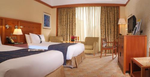 a hotel room with two beds and a television at Holiday Inn Kuwait by IHG in Kuwait
