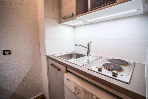 une petite cuisine avec un évier et une cuisinière dans l'établissement Résidence Pierres Plates G - PIERRES PLATES 31 MAE-1921, à Valmorel