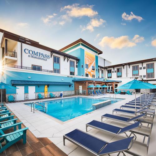 a pool at the inn with lounge chairs at Compass by Margaritaville Flagler Beach in Flagler Beach