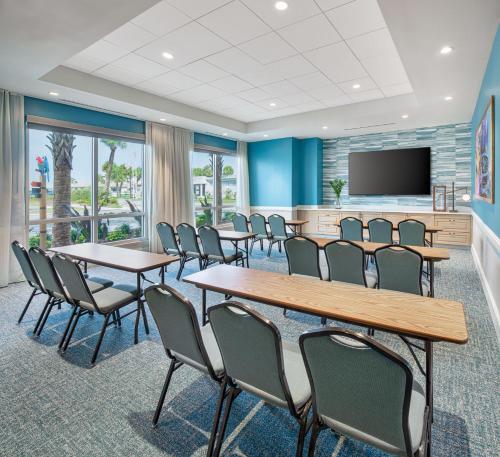 a conference room with tables and chairs and a flat screen tv at Compass by Margaritaville Flagler Beach in Flagler Beach