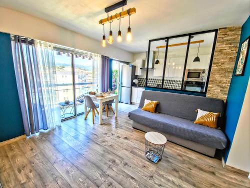 a living room with a couch and a table at Beachfront - Panoramic View - Balkony - AC in Cagnes-sur-Mer