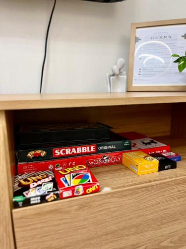 a book shelf filled with books and othergames at Cozy 2BR Stay for 6pax in High-Floor, Wi-Fi & Family Games near IT Park Cebu- Unit Scarlett by GERRA in Mandaue City