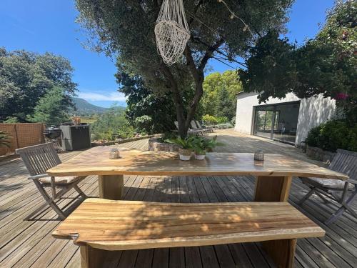 a wooden table and benches on a wooden deck at A Casa Catalina - Charming villa in Afa