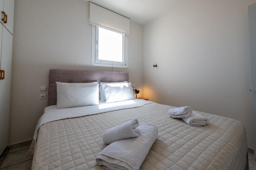 a bedroom with a large white bed with towels on it at Mythos Suites-Poseidon apartment in Methoni
