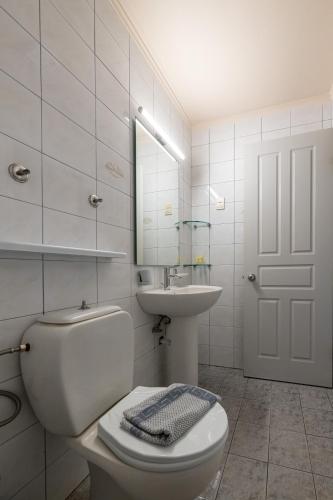 a white bathroom with a toilet and a sink at Mythos Suites-Poseidon apartment in Methoni