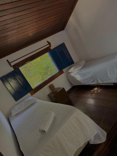 a room with two beds and a map on the wall at Pousada Bons Ventos in Paraty