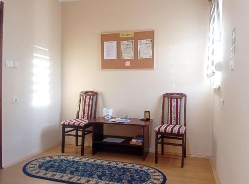 a room with two chairs and a desk and a table at Kuća Amazonija in Apatin