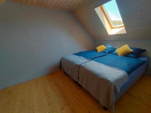 a bedroom with a bed with blue sheets and a window at Sielsko Anielsko -Domki Swornegacie in Swornegacie 