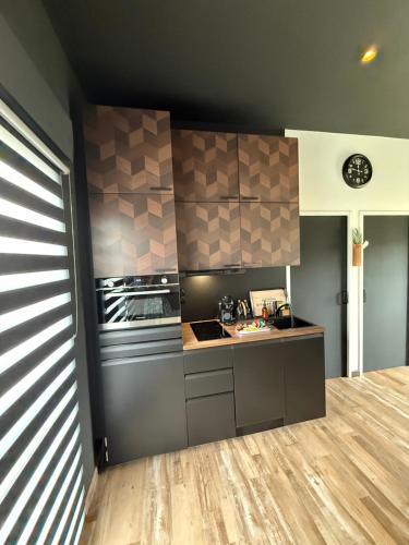 a kitchen with a stove and a counter top at Jardin Secret in Groffliers
