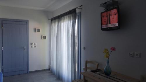 a room with a window and a vase of flowers on a table at Zathea Apartments in Agia Pelagia Kythira