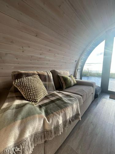 a large bed in a room with a wooden wall at Danu Resort in Castlerock