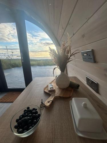 a table with a bowl of blackberries on a table with a window at Danu Resort in Castlerock