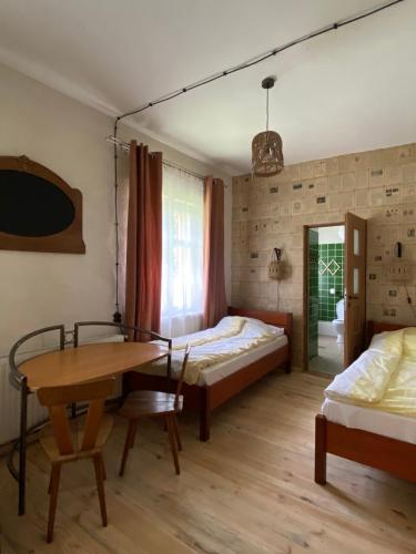 a bedroom with two beds and a desk and a table at Stary młyn nad Tywą in Gryfino