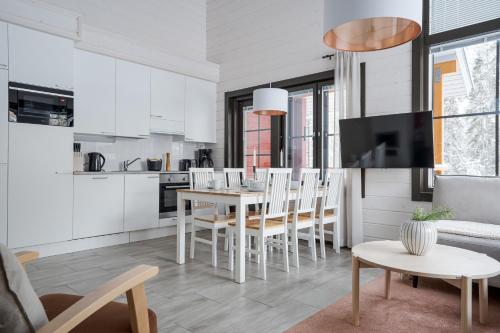 eine Küche und ein Wohnzimmer mit Tisch und Stühlen in der Unterkunft Auroralevi Sointuilevi B63, Central, Sauna, Ski nearby in Levi