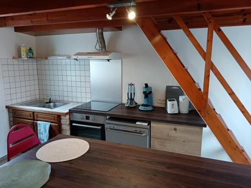 a kitchen with a table and a counter top at Maison Le Wetz Calme, Confort in Sainte-Marie-Kerque