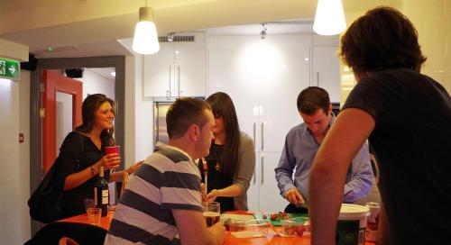 a group of people standing around a table in a kitchen at Galway City Hostel - Solo Traveller Hostel in Galway