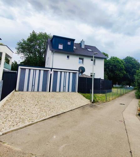 a white house with a blue gate and a fence at Ferienwohnung Gartenblick zentral und komfortabel in Laupheim