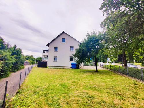 a white house with a tree in a yard at Ferienwohnung Gartenblick zentral und komfortabel in Laupheim