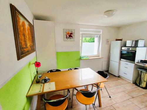 a kitchen with a table and chairs and a refrigerator at Ferienwohnung Gartenblick zentral und komfortabel in Laupheim