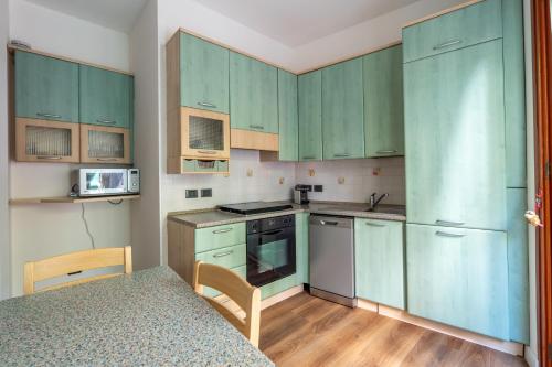 a small kitchen with green cabinets and a table at Rapallo Charm in green in Rapallo