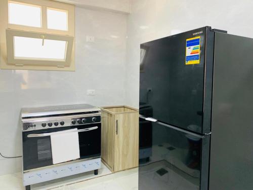 a kitchen with a stainless steel refrigerator and a stove at شاليه بقريه جرين بيتش الساحل الشمالي 4 غرف تشطيب السنه لوكس in El Alamein