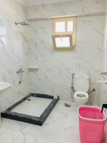 a white bathroom with a toilet and a sink at شاليه بقريه جرين بيتش الساحل الشمالي 4 غرف تشطيب السنه لوكس in El Alamein