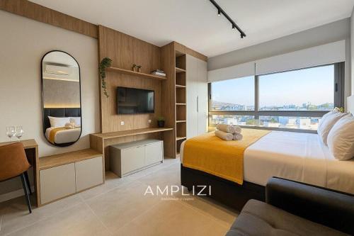 a bedroom with a large bed and a television at Linked Ampllizi in Porto Alegre