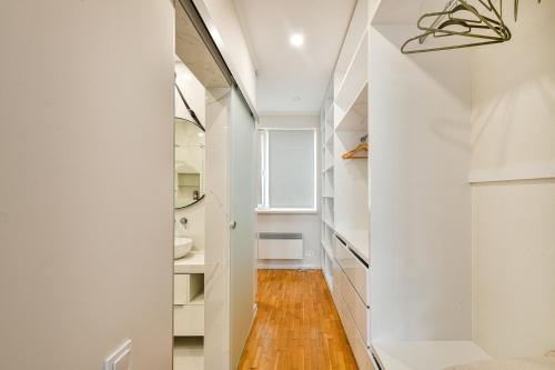 un corridoio con pareti bianche e pavimenti in legno di Carpe vita 1BR Pool & Parking a Varna