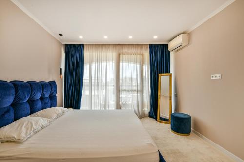 una camera con letto e testiera blu di Carpe vita 1BR Pool & Parking a Varna