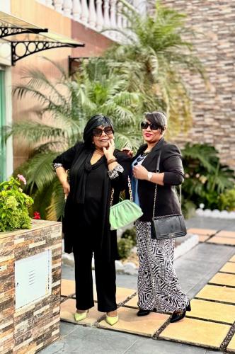 two women standing next to each other on a sidewalk at Hotel Coqueiros in Valparaíso de Goiás