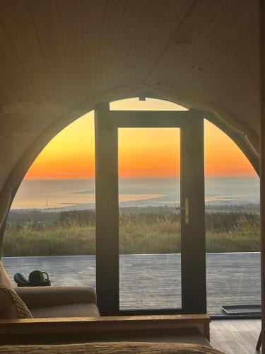 een kamer met uitzicht op de zonsondergang door een raam bij Danu Resort in Castlerock