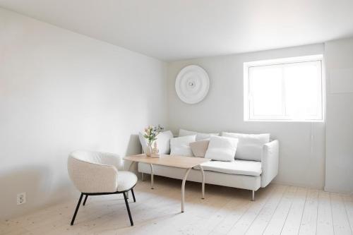 a white living room with a white couch and a table at Ny og moderne leilighet i Bodø Sentrum! in Bodø