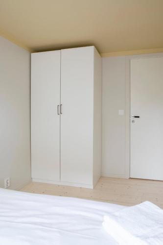 an empty bedroom with white wardrobes at Ny og moderne leilighet i Bodø Sentrum! in Bodø