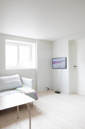 a white room with a couch and a tv at Ny og moderne leilighet i Bodø Sentrum! in Bodø