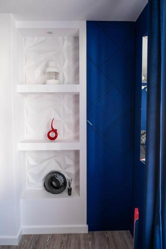 a blue door in a room with white shelves at ApArt Gallery Apartment 2, Stylish 3- Bed , Free Parking ,Sleeps 6 in Bedford