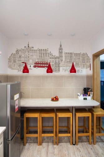 a kitchen with a table with chairs and a refrigerator at ApArt Gallery Apartment 2, Stylish 3- Bed , Free Parking ,Sleeps 6 in Bedford