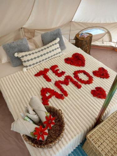 a bed with a sign that says sleep in a tent at La villa Glamping in Buga