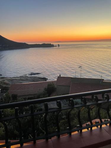 a view of the ocean at sunset from a balcony at Campese Apartments in Campese