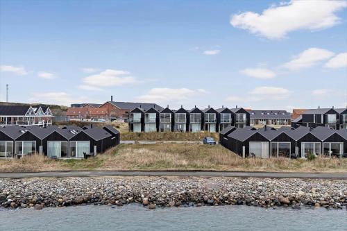 a row of houses on a hill next to the water at 7716-Hvide-Sande-Slusen-16 in Hvide Sande