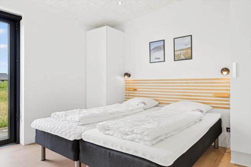 three beds in a room with white walls at 4426-Hvide-sande-Granvej-4 in Hvide Sande