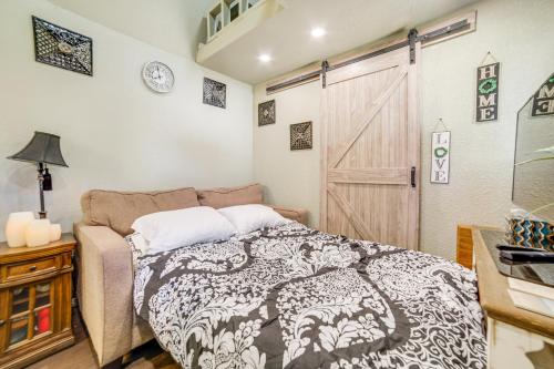 1 dormitorio con cama y puerta de granero en Cozy Tiny Home 1 Mi to The Village at Meridian, en Meridian