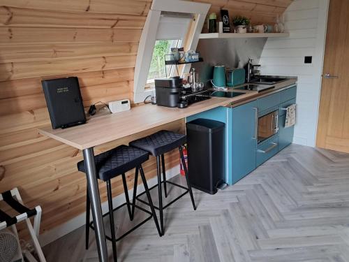 a kitchen with a wooden counter and blue cabinets at Beinn View Pod in Corpach