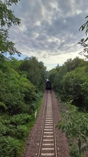 a train is traveling down the train tracks at Beinn View Pod in Corpach