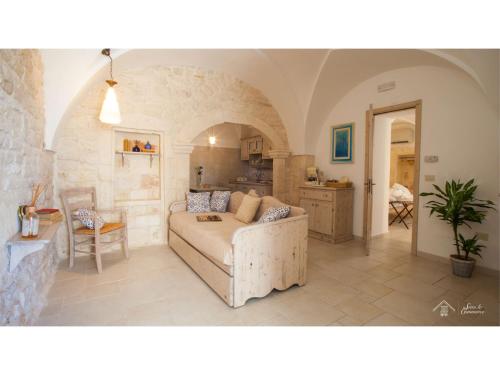 a living room with a couch and a kitchen at Albergo Diffuso Sotto le Cummerse in Locorotondo