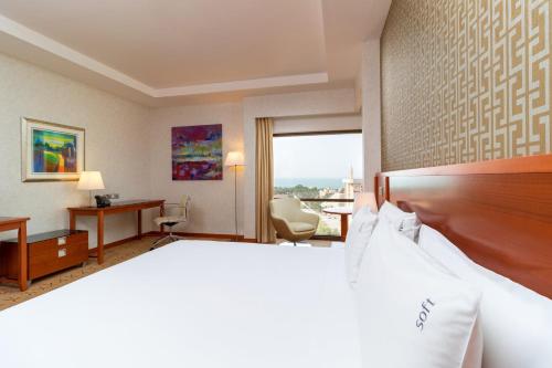 a hotel room with a bed and a desk at Holiday Inn - Suites Kuwait Salmiya by IHG in Kuwait