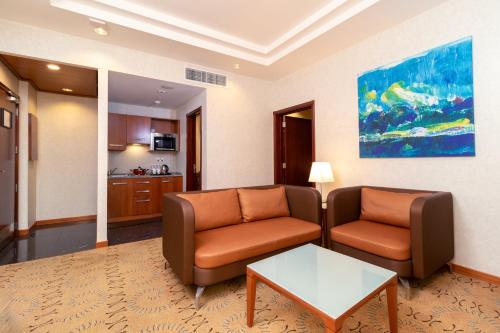 a living room with two chairs and a table at Holiday Inn - Suites Kuwait Salmiya by IHG in Kuwait