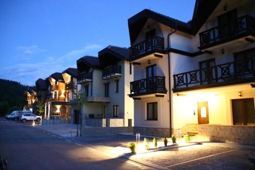 a building with lights on the side of a street at Apartment MonteBreza Spa in Kolašin