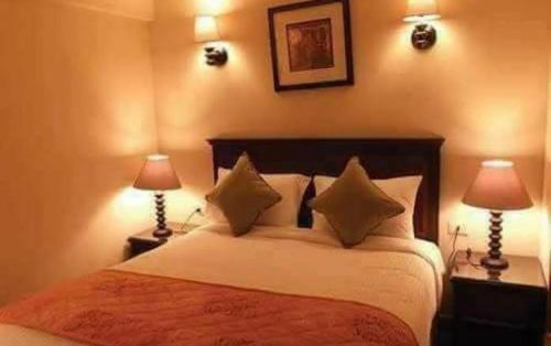 a bedroom with a large bed with two lamps at porto south beach from amer group شاليه فندقى من عامر جروب فى بورتو ساوث بيتش منطقه التايم شير المميزه in Ain Sokhna