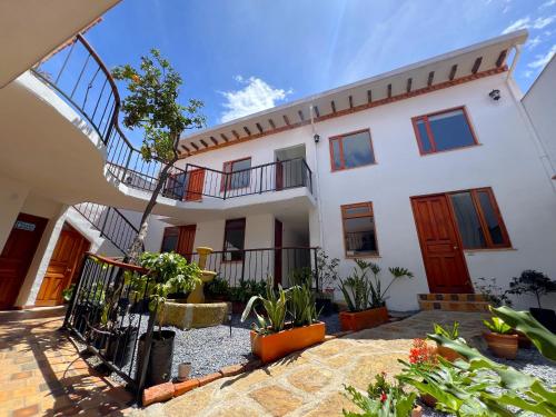 a house with a staircase in a courtyard at Hotel Villa Macondo in Villa de Leyva